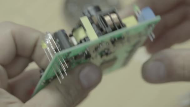 Un travailleur travaille à la production d'une carte électronique. Gros plan .