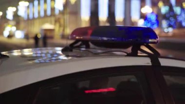 Gece bir polis arabasının çatısında teşhirci. Yanıp sönen.