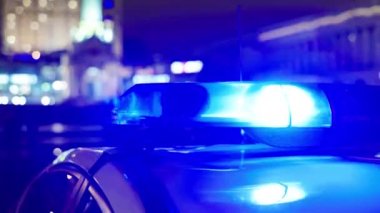 Gece bir polis arabasının çatısında teşhirci. Yanıp sönen.