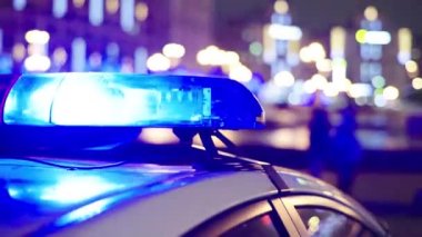 Gece bir polis arabasının çatısında teşhirci. Yanıp sönen.
