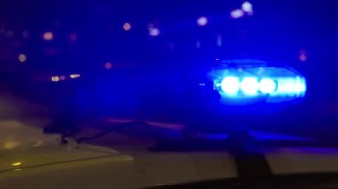 Gece bir polis arabasının çatısında teşhirci. Yanıp sönen.