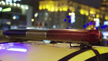 Gece bir polis arabasının çatısında teşhirci. Yanıp sönen.