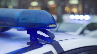 Gece bir polis arabasının çatısında teşhirci. Yanıp sönen.