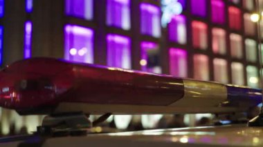 Gece bir polis arabasının çatısında teşhirci. Yanıp sönen.