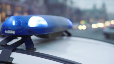 Gece bir polis arabasının çatısında teşhirci. Yanıp sönen.