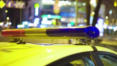 Gece bir polis arabasının çatısında teşhirci. Yanıp sönen.