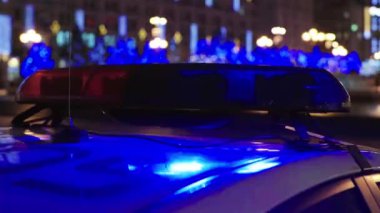 Gece bir polis arabasının çatısında teşhirci. Yanıp sönen.