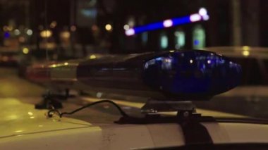 Gece bir polis arabasının çatısında teşhirci. Yanıp sönen.