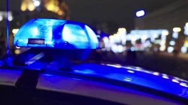 Gece bir polis arabasının çatısında teşhirci. Yanıp sönen.