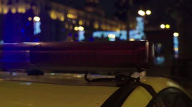 Gece bir polis arabasının çatısında teşhirci. Yanıp sönen.