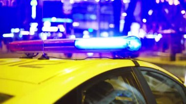 Gece bir polis arabasının çatısında teşhirci. Yanıp sönen.