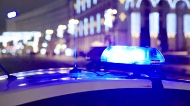Gece bir polis arabasının çatısında teşhirci. Yanıp sönen.