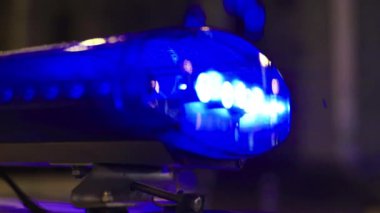 Gece bir polis arabasının çatısında teşhirci. Yanıp sönen.