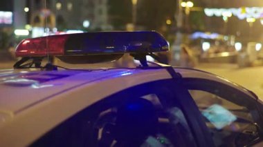 Gece bir polis arabasının çatısında teşhirci. Yanıp sönen.