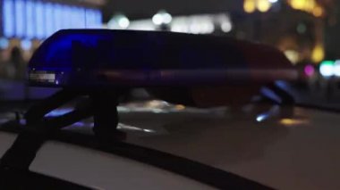 Gece bir polis arabasının çatısında teşhirci. Yanıp sönen.