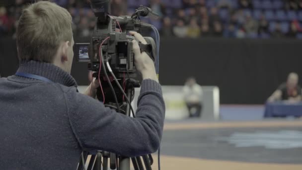 Cameraman met een camera in worstelwedstrijden. Close-up. — Stockvideo