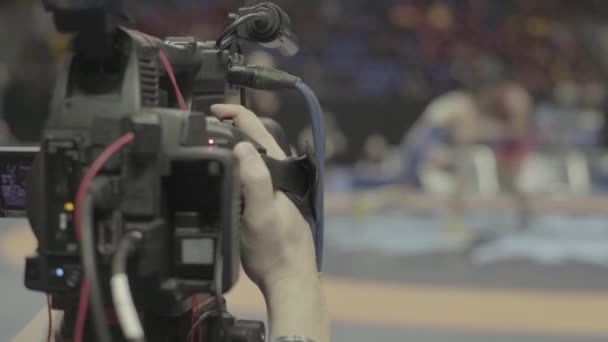 Cameraman met een camera in worstelwedstrijden. Close-up. — Stockvideo