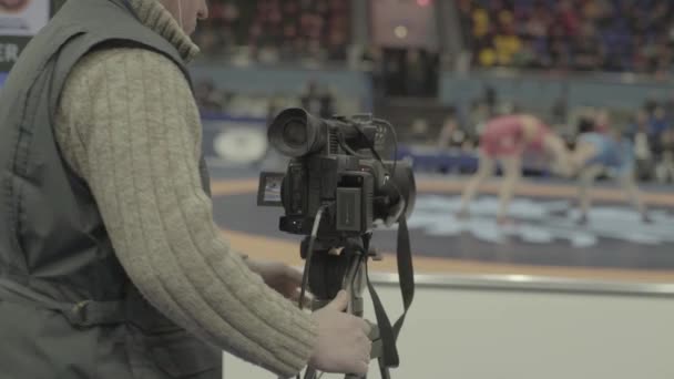 Cameraman met een camera in worstelwedstrijden. Close-up. — Stockvideo