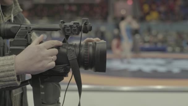 Cameraman met een camera in worstelwedstrijden. Close-up. — Stockvideo