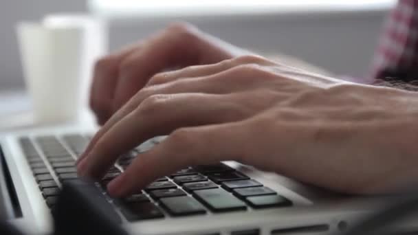 Een man werkt op een laptop op kantoor. Close-up. — Stockvideo