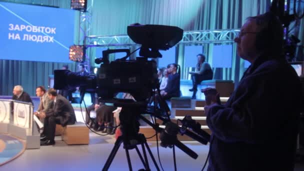 Cameraman met een camera in een tv-studio tijdens het opnemen van tv-uitzendingen. — Stockvideo