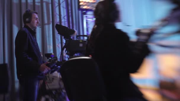 Cameraman con una fotocamera in uno studio televisivo durante la registrazione di trasmissioni televisive . — Video Stock