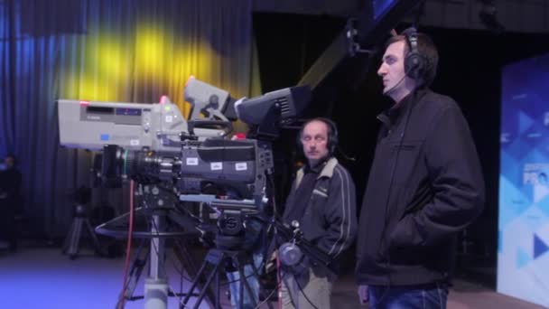 Cameraman met een camera in een tv-studio tijdens het opnemen van tv-uitzendingen. — Stockvideo