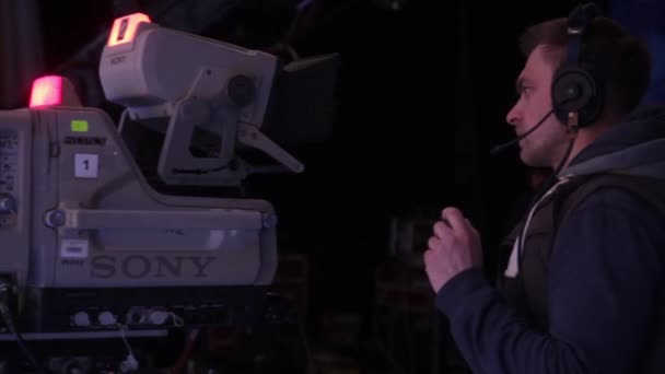 Cameraman met een camera in een tv-studio tijdens het opnemen van tv-uitzendingen. — Stockvideo