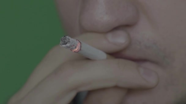 Zigarette im Mund eines Rauchers. Nahaufnahme. Zeitlupe. Chroma-Schlüssel. grüner Hintergrund. — Stockvideo