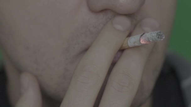 Cigaretta egy dohányos szájában. Közelkép. Lassú mozgás. Krómkulcs. Zöld háttér. — Stock videók