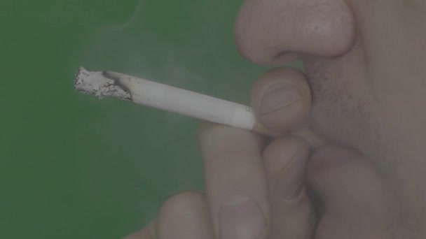 La cigarette dans la bouche d'un fumeur. Gros plan. Au ralenti. Chroma Key. Fond vert .