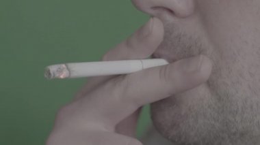 Sigara içen birinin ağzında sigara. Yakın plan..