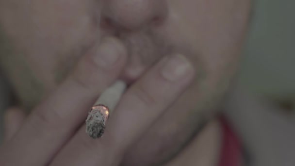 La cigarette dans la bouche d'un fumeur. Gros plan .