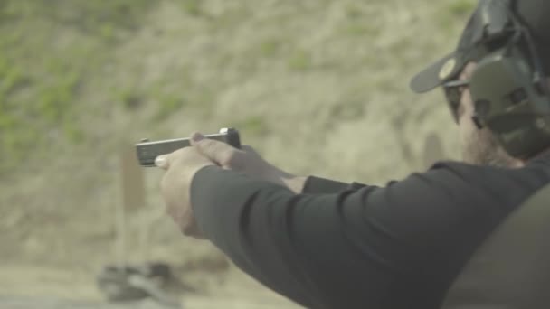 Mannen skjuter med en pistol. — Stockvideo