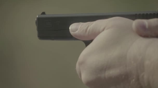 Närbild av en pistol. Långsamma rörelser. — Stockvideo