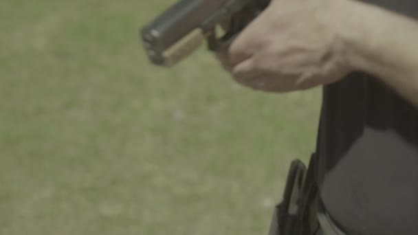 Närbild av en pistol. Långsamma rörelser. — Stockvideo