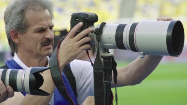 Egy fotós, fotósok egy kamerával a stadionban egy focimeccs alatt. — Stock videók