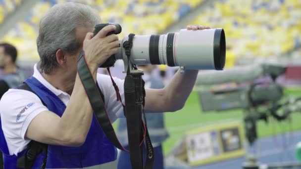 Seorang fotografer, fotografer dengan kamera di stadion selama pertandingan sepak bola . — Stok Video
