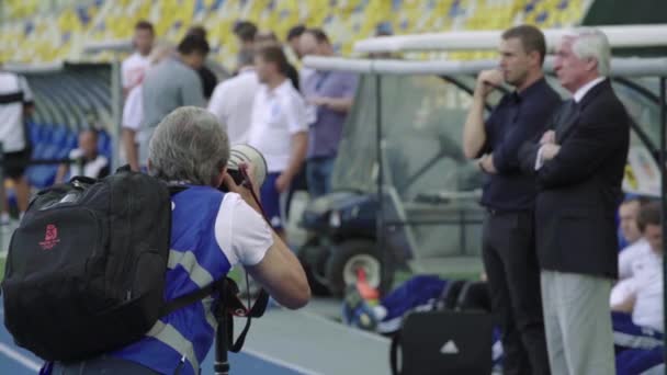 Fotograf, fotograf z kamerą na stadionie podczas meczu piłki nożnej. — Wideo stockowe