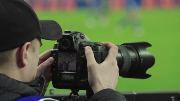 Fotograf, fotografer med kamera på stadion under en fotbollsmatch. — Stockvideo