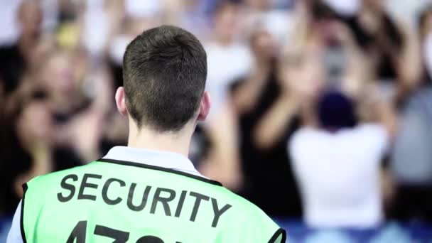 Guardia de seguridad masculino en un estadio durante un partido de fútbol . — Vídeos de Stock