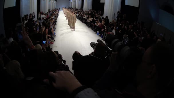 Modeshow. Groep van modellen wandelen op de catwalk — Stockvideo