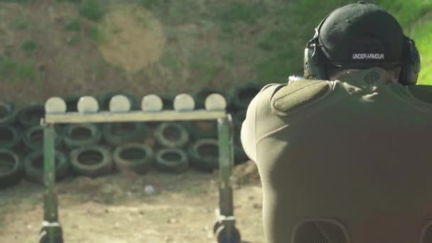 Egy férfi lövöldözik egy pisztollyal. — Stock videók