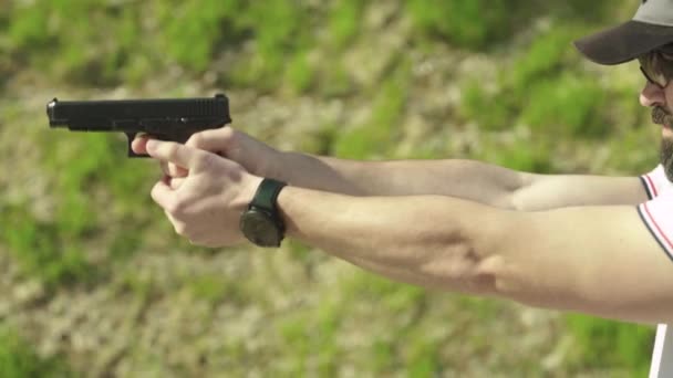 Mannen skjuter med en pistol. — Stockvideo