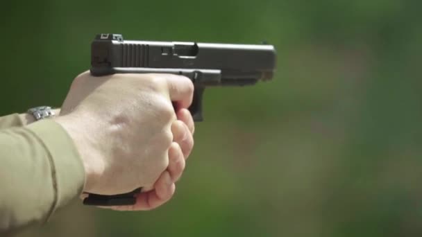 Närbild av en pistol. Långsamma rörelser. — Stockvideo