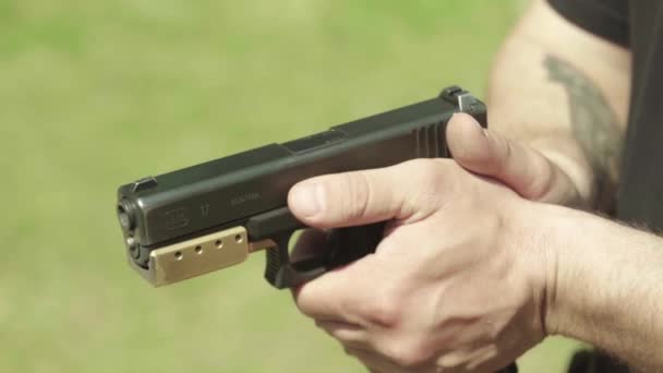 Närbild av en pistol. Långsamma rörelser. — Stockvideo