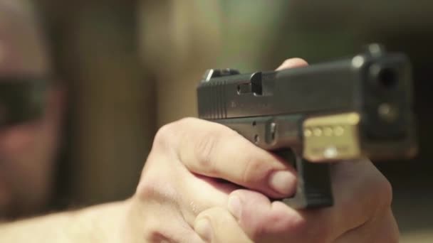 Närbild av en pistol. Långsamma rörelser. — Stockvideo