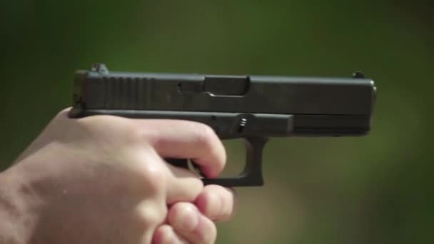 Närbild av en pistol. Långsamma rörelser. — Stockvideo