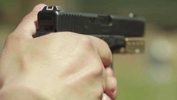 Närbild av en pistol. Långsamma rörelser. — Stockvideo