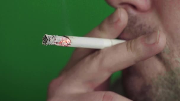 Cigaretta egy dohányos szájában. Közelkép. Krómkulcs. Zöld háttér. — Stock videók